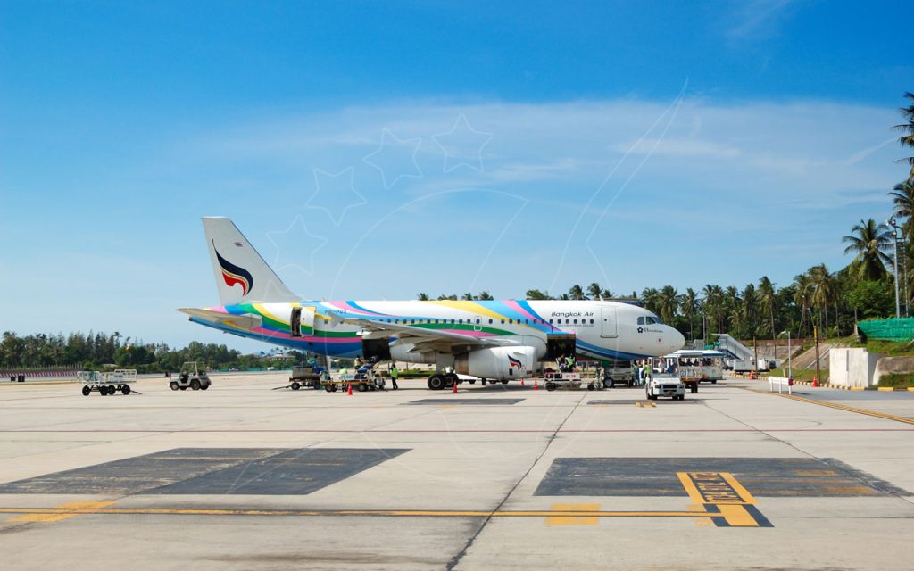 طائرة إيرباص A319 لبانكوك إير على مدرج مطار استوائي مع أشجار نخيل وطاقم أرضي