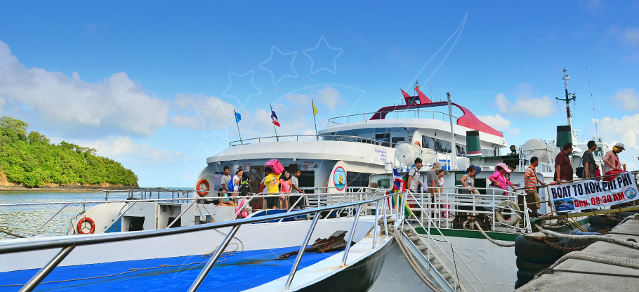 Ferries atracados no cais com passageiros a embarcar, placa com 'Boat to Koh Phi Phi'