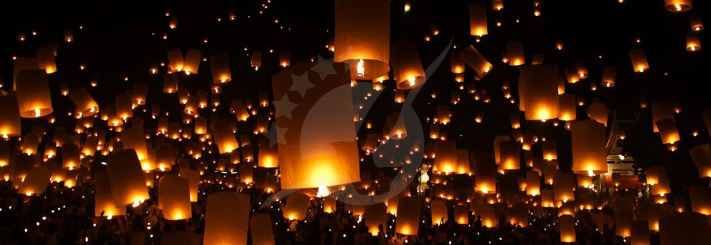 Milhares de lanternas de papel a brilhar no céu noturno durante um festival cultural